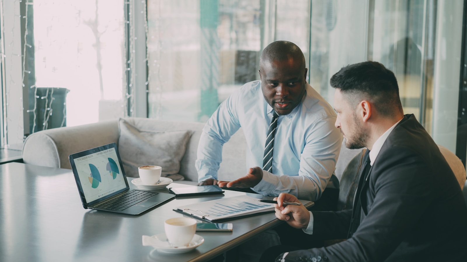 Two advisors reviewing financial charts and reports together at a table