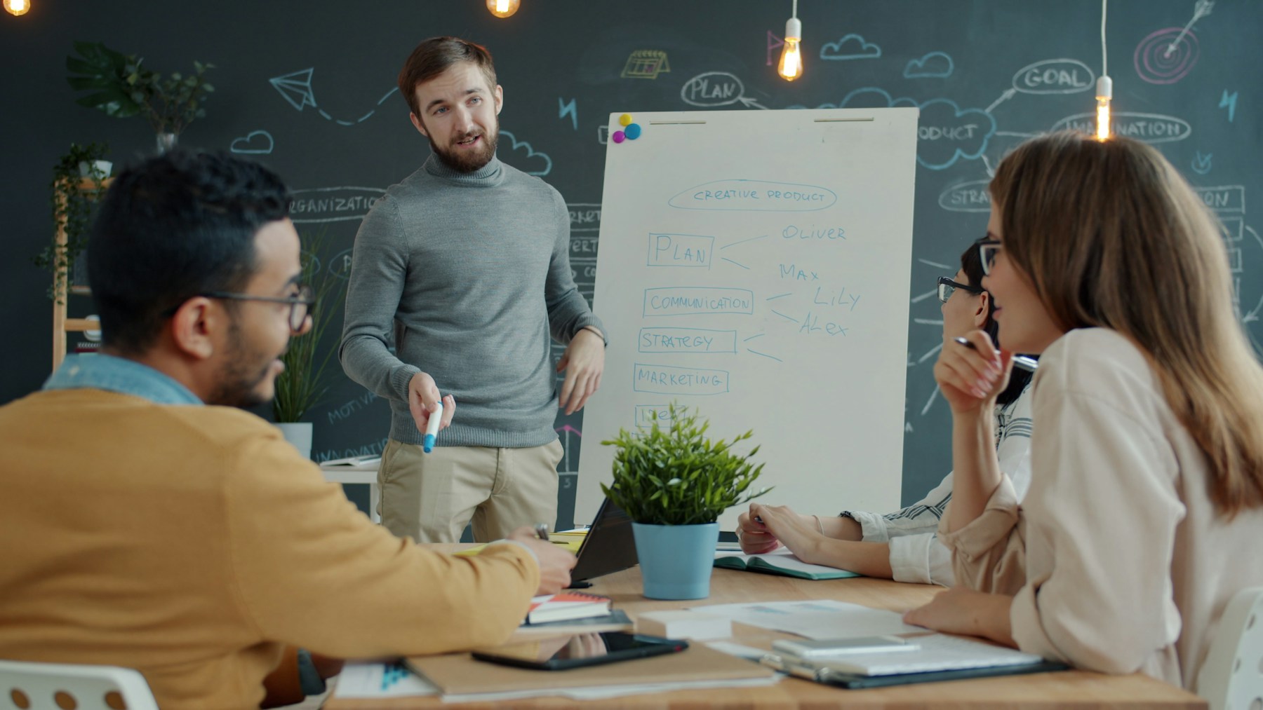 A facilitator leading a strategy working session with a team around a whiteboard